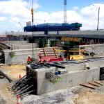 construction of various structures throughout the project including capping beams, retaining walls, post tensioned beams, reinforced concrete beams, deck slabs and pavement works.